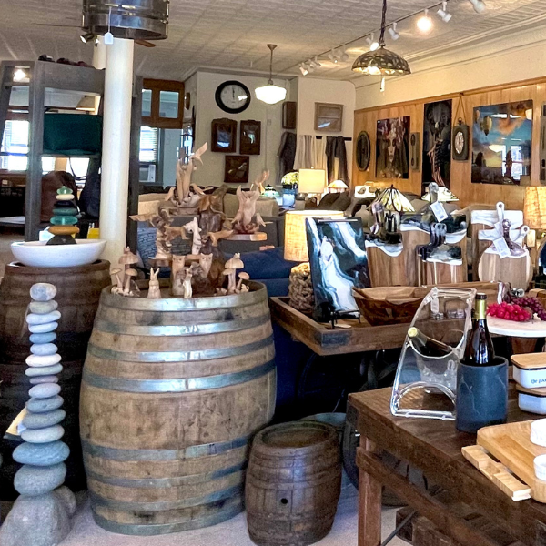 Inside a shop with wooden barrels, decor, and art.