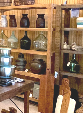 Wooden shelves displaying various jars and containers in a shop.