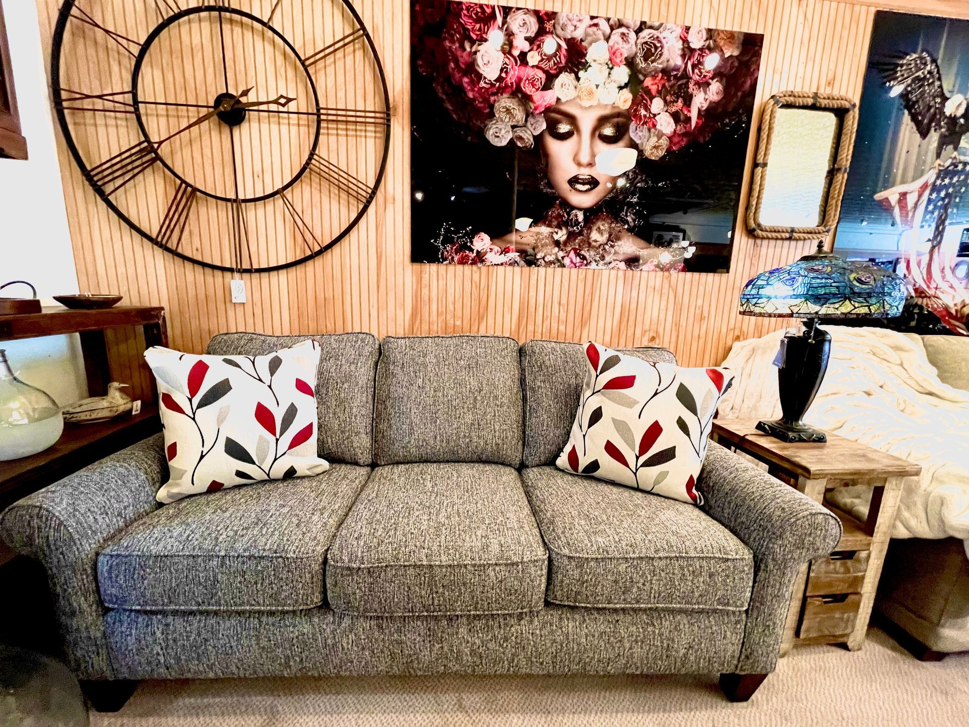 Grey sofa with patterned pillows in a room with art and decor.