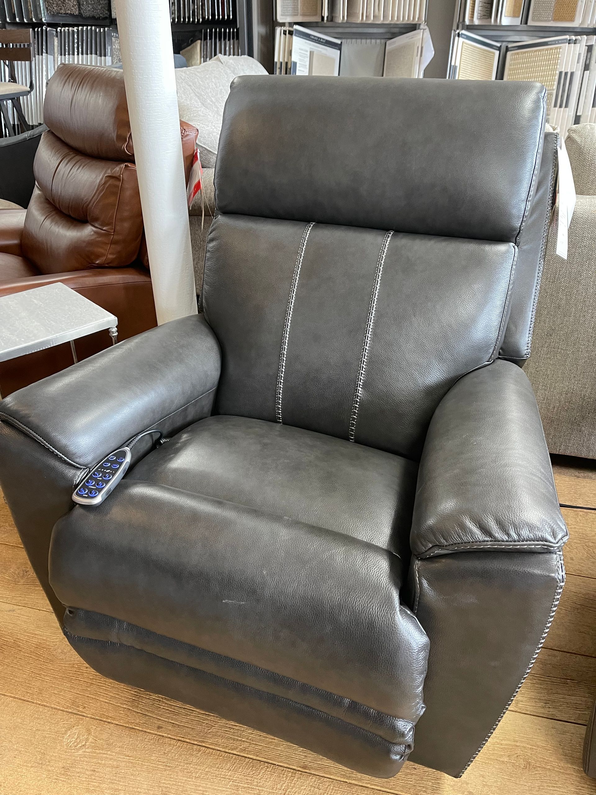 Gray leather recliner chair in a furniture showroom.