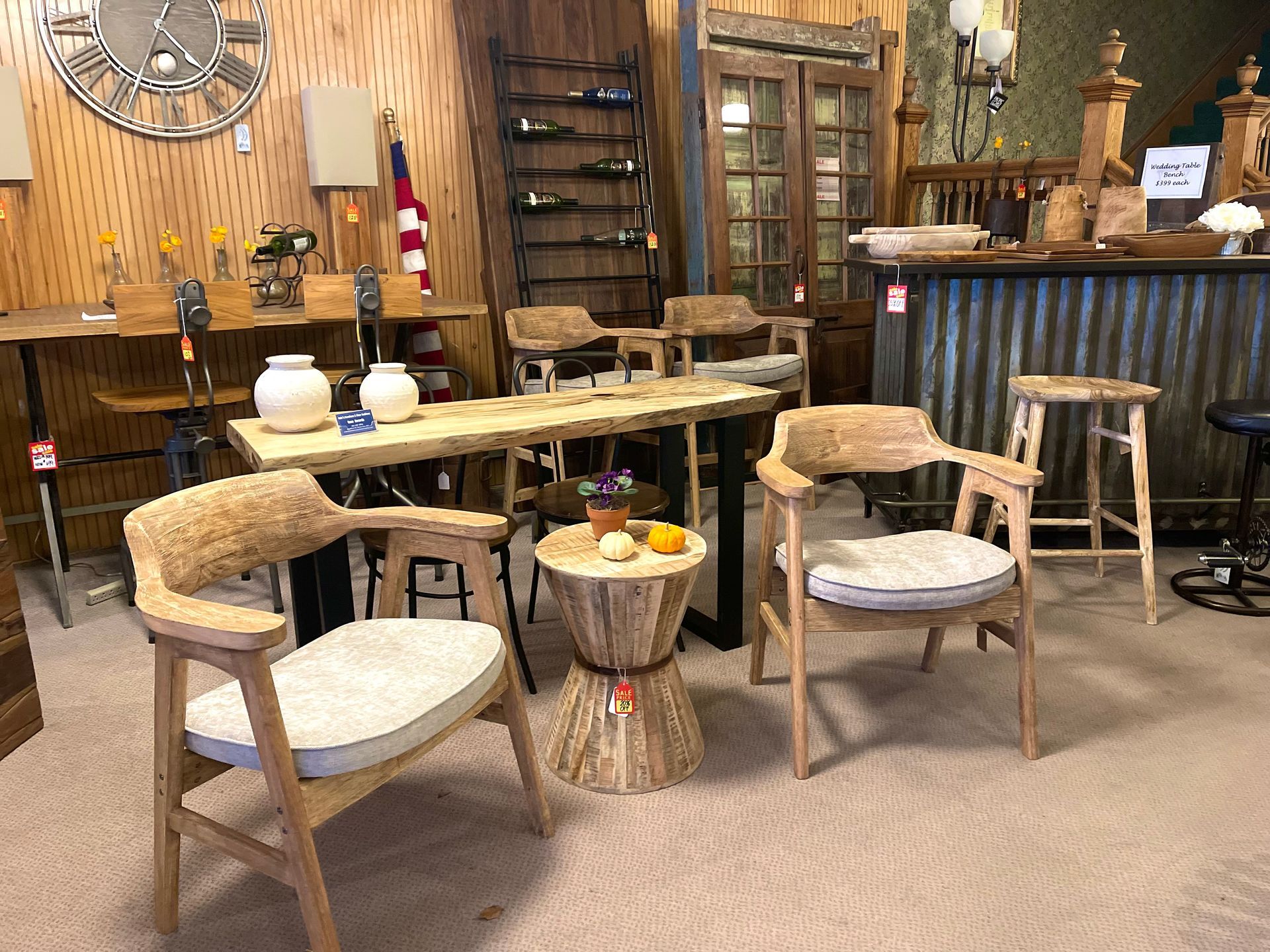 Rustic furniture showroom featuring chairs, tables, and a bar.