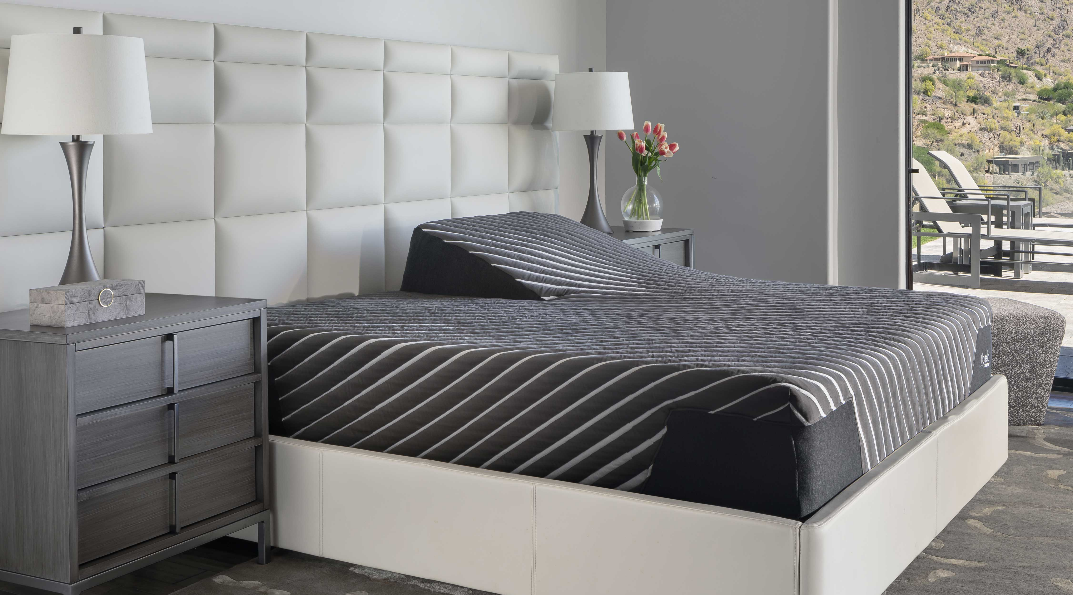 Gray and white bedroom with a modern bed, nightstands, and large window with a patio view.