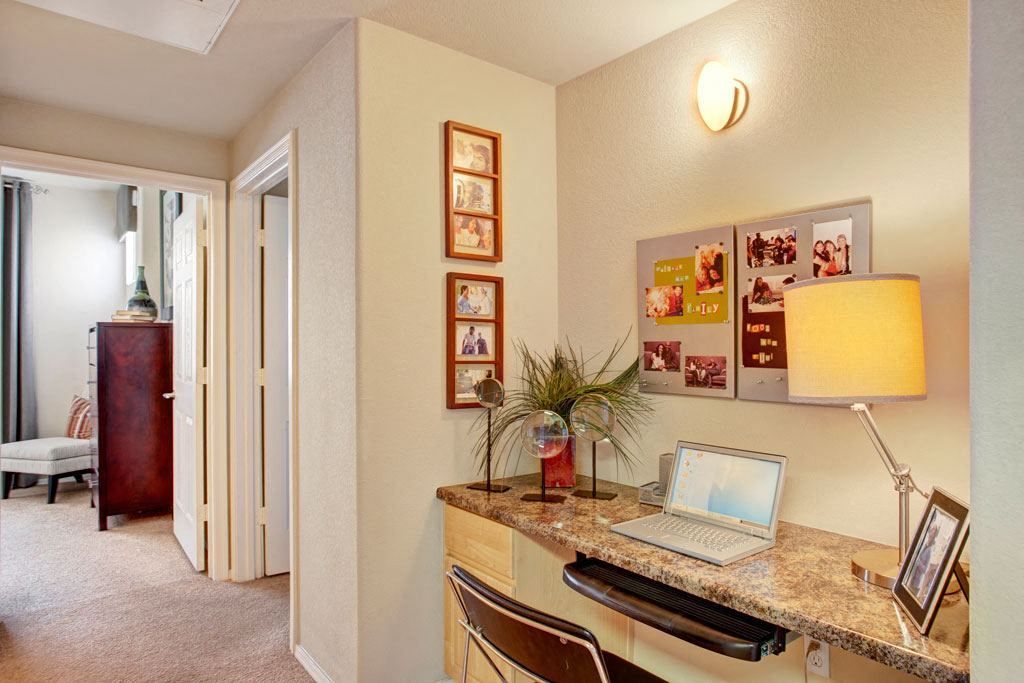 A room with a desk and a laptop on it
