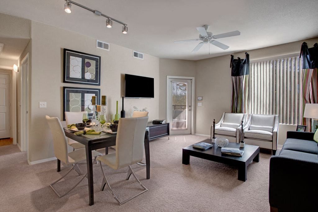 A living room with a couch , table , chairs and a television.
