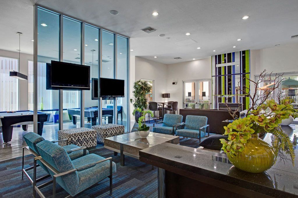 A living room with a lot of furniture and televisions