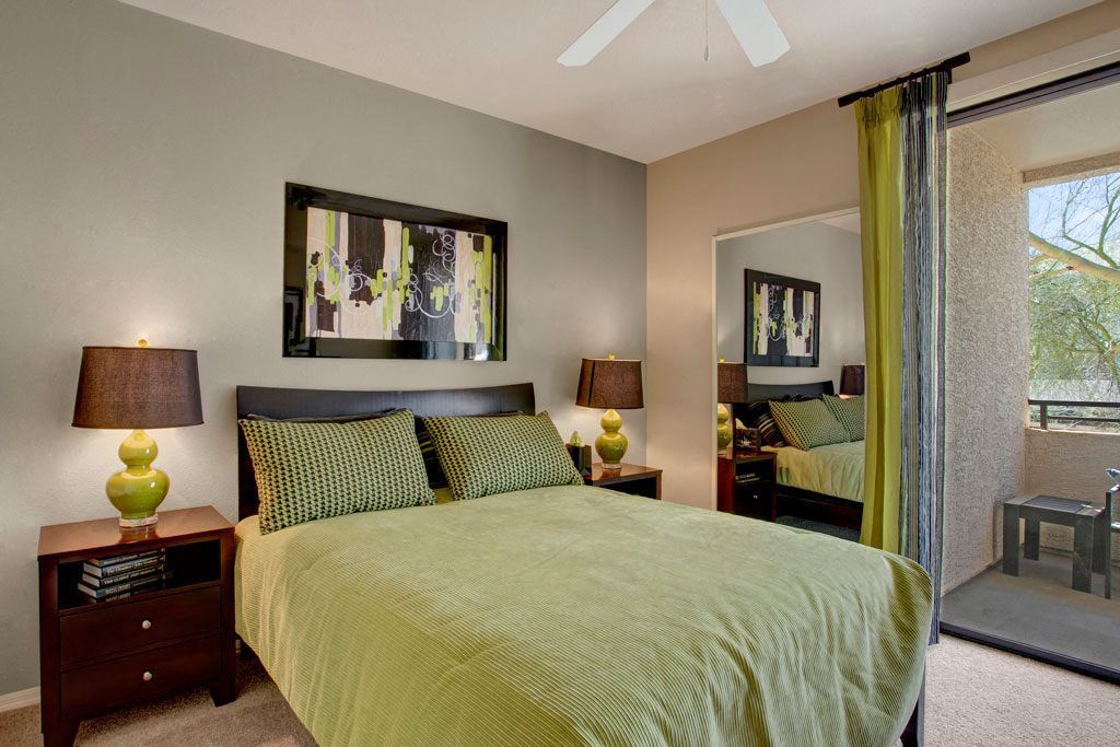 A bedroom with a large bed and a ceiling fan