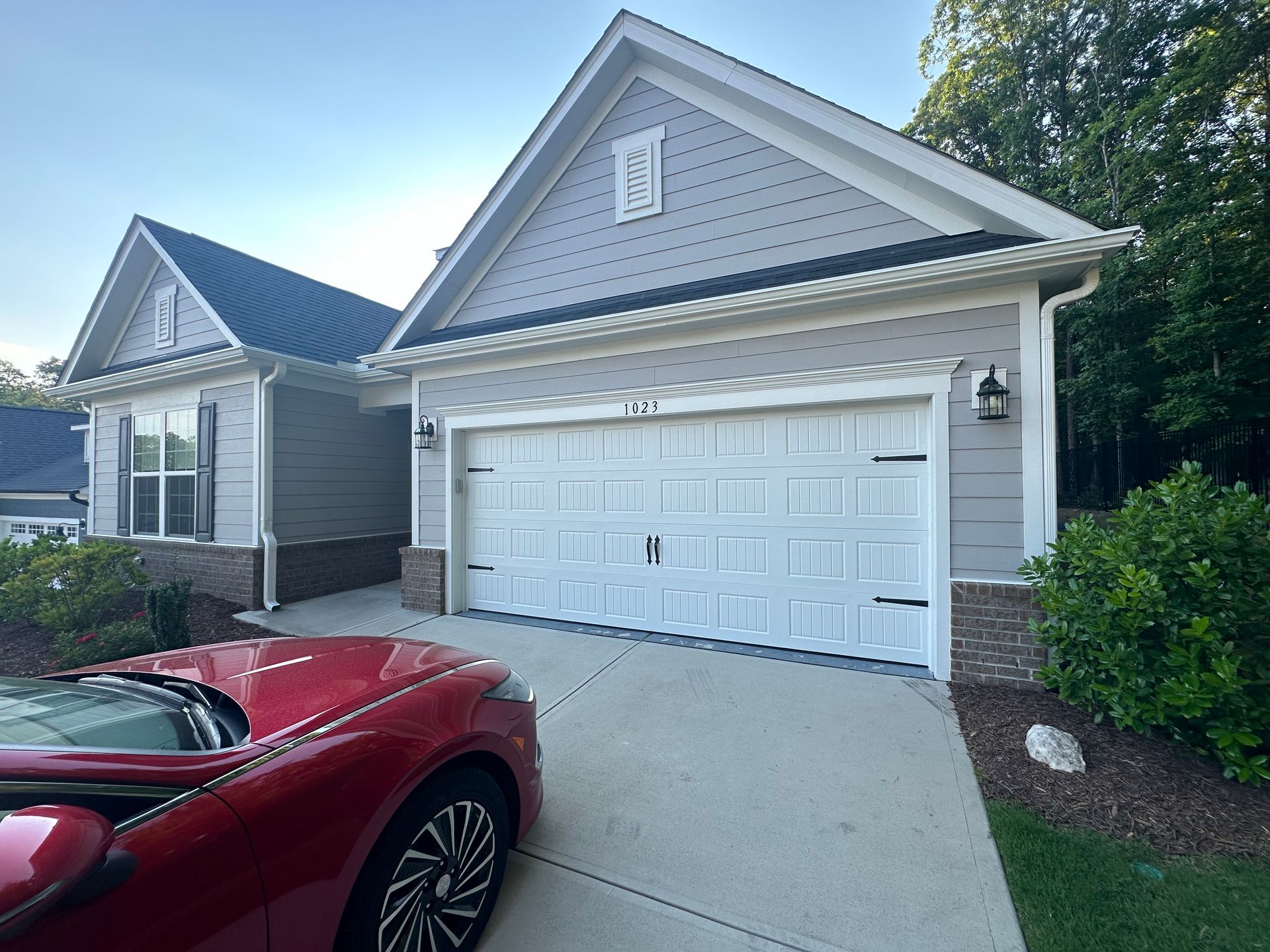There are three garage doors on the side of a house.