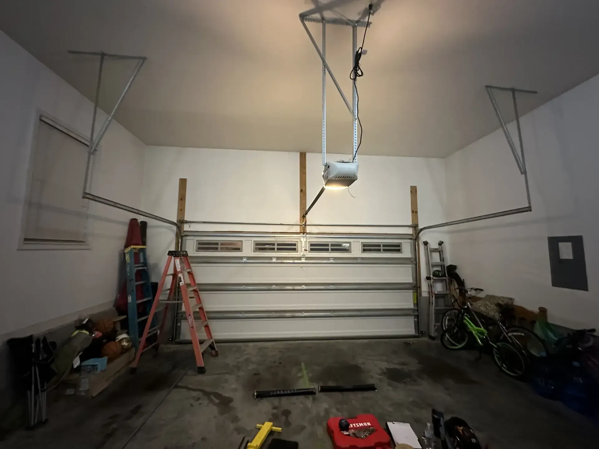 A garage with a ladder and a garage door opener
