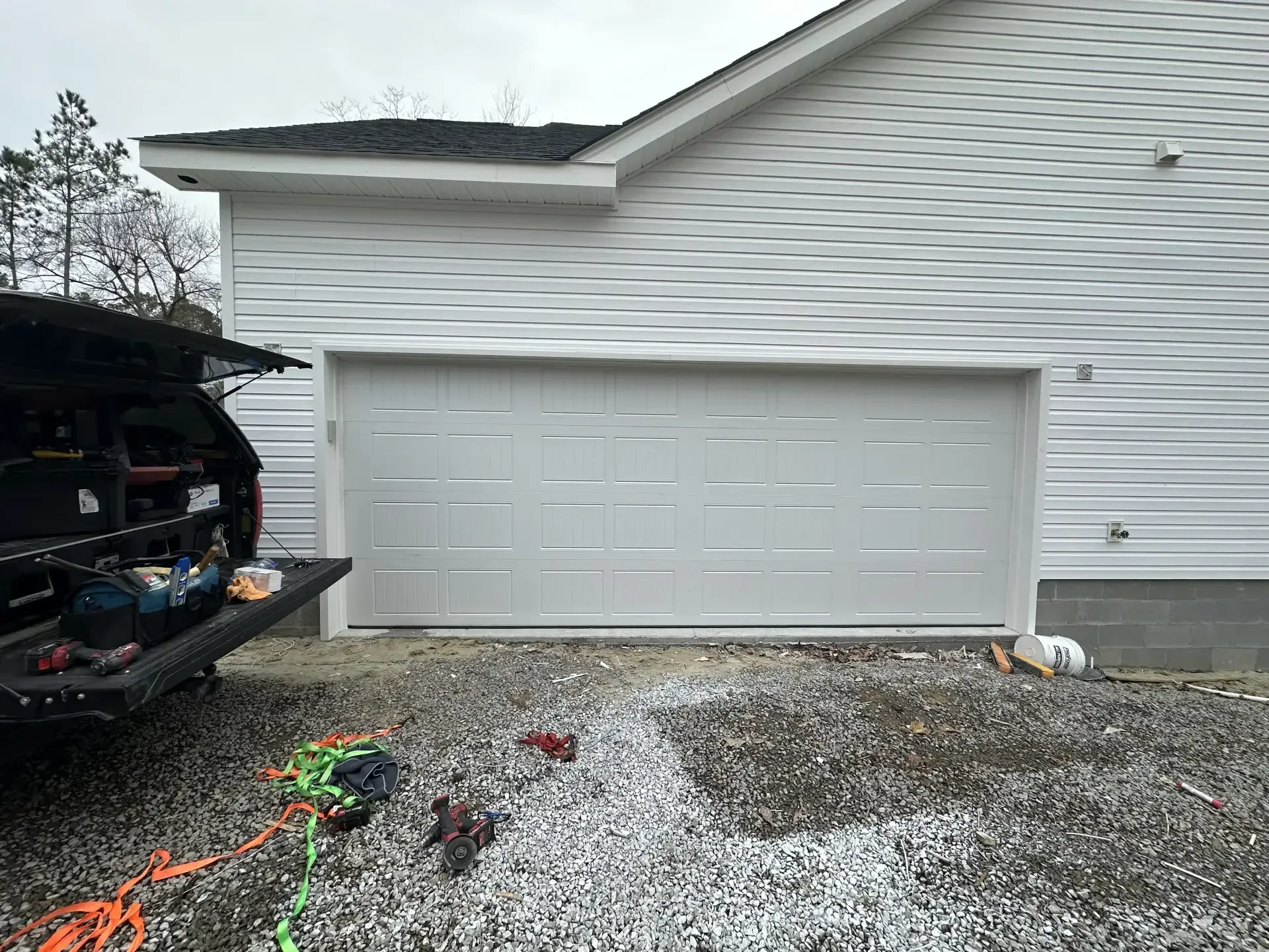 A white garage door is being installed on a house.