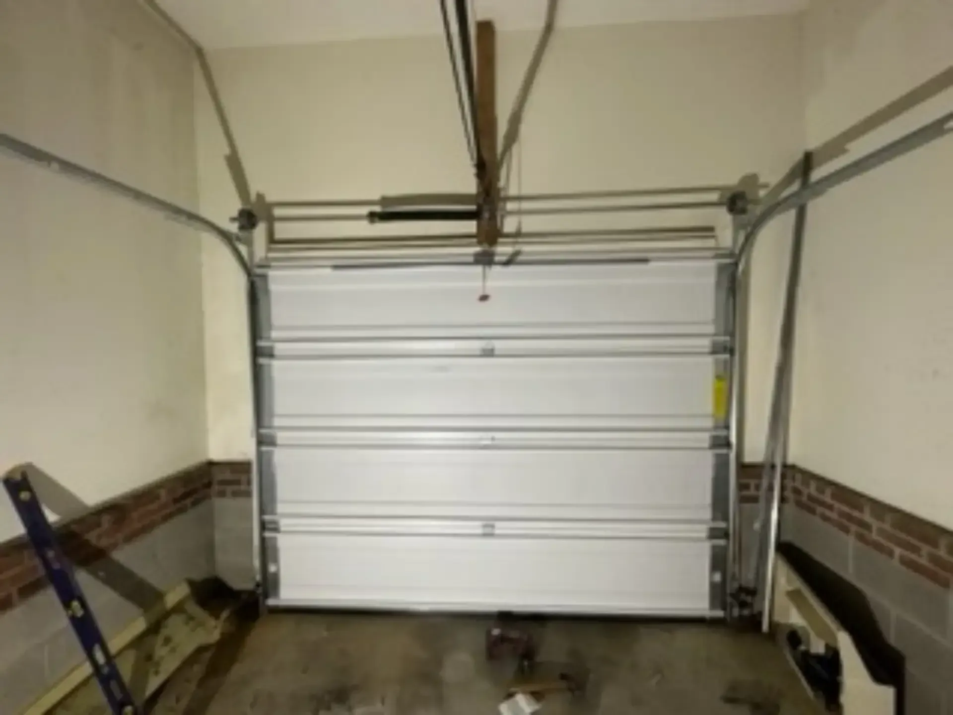 A white garage door is open in a garage.