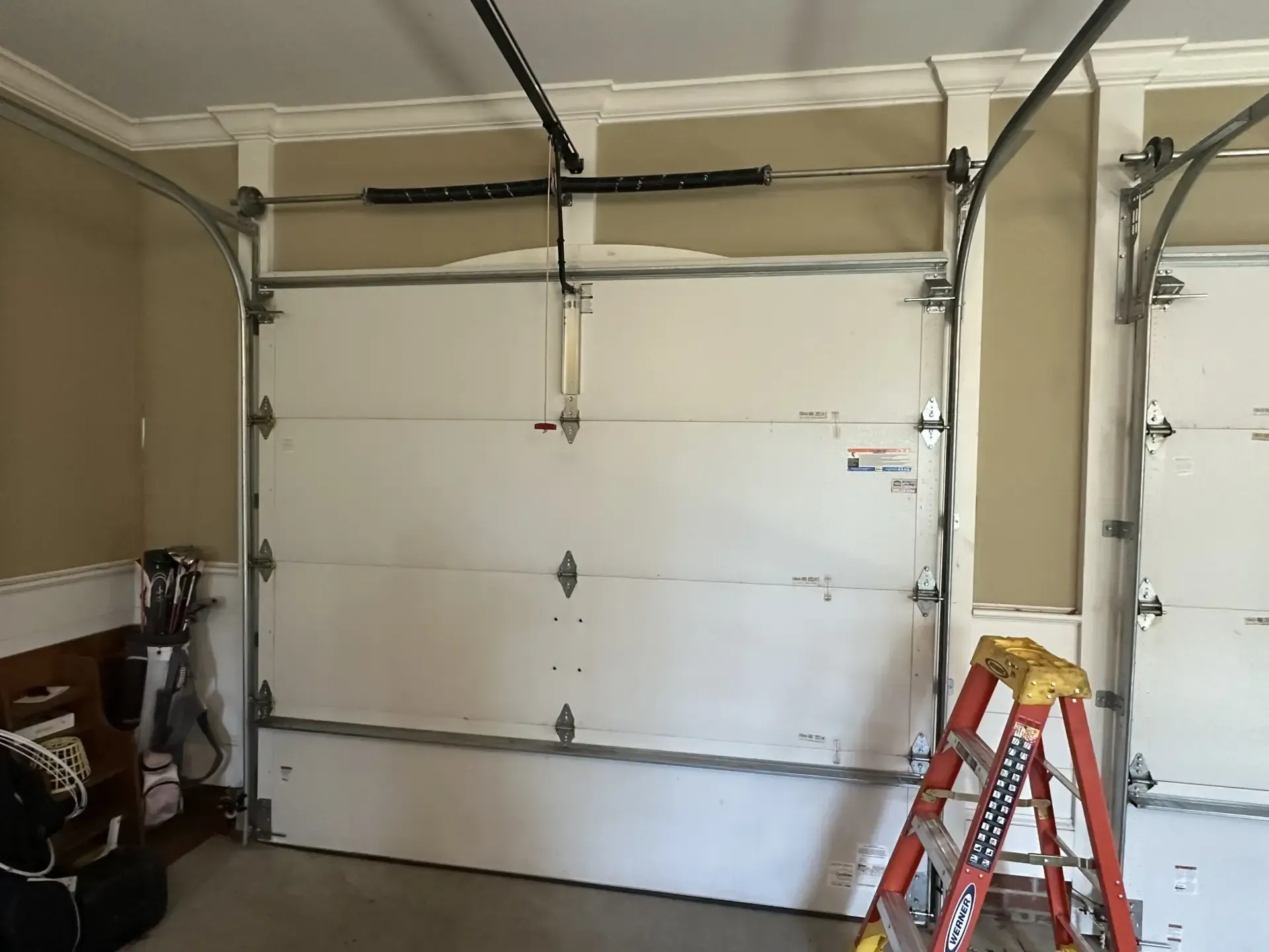 A garage door with a ladder in front of it.