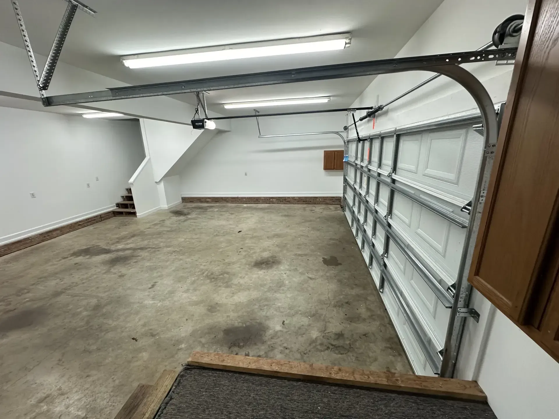 An empty garage with a garage door open.