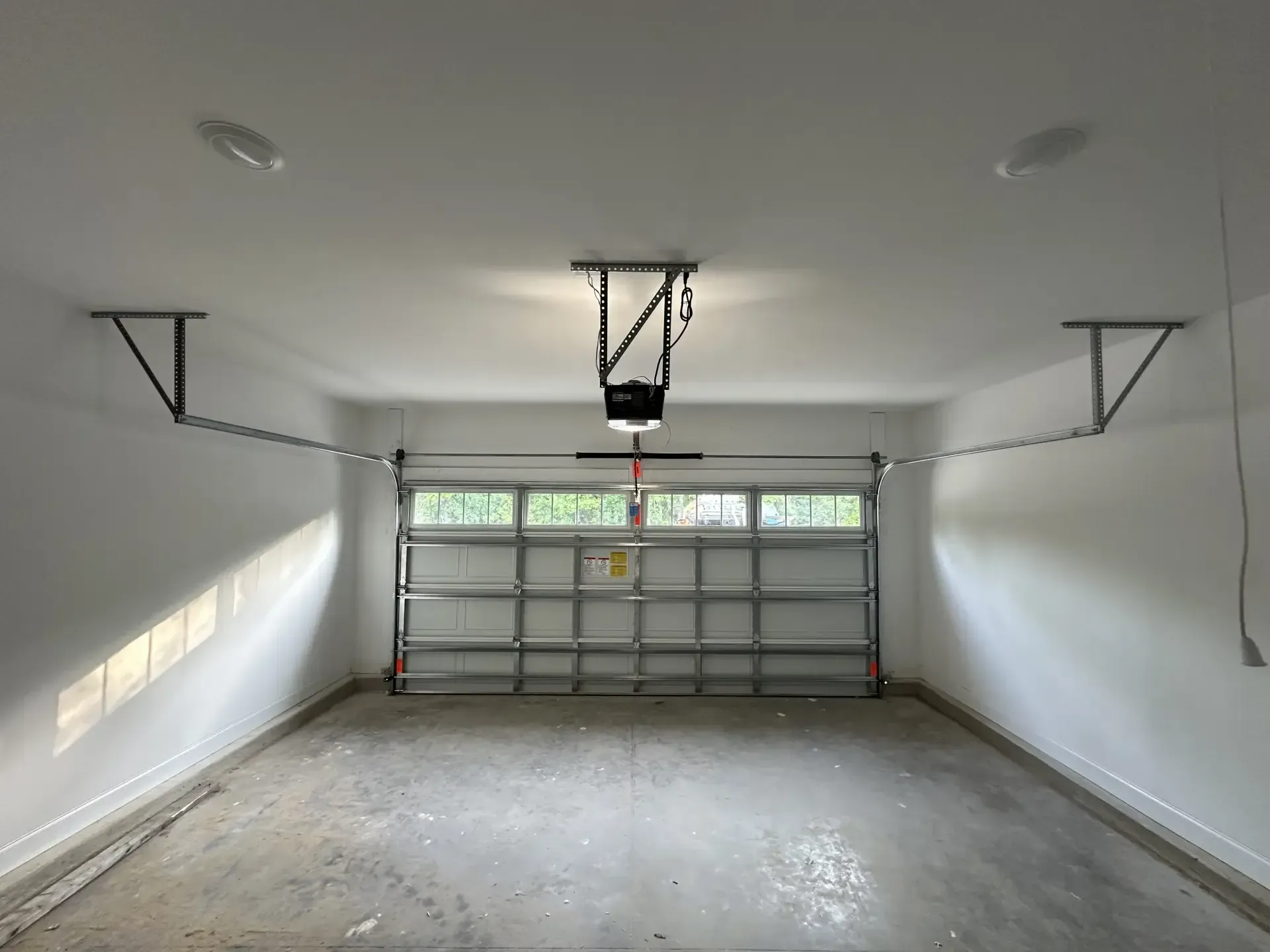 An empty garage with a garage door open