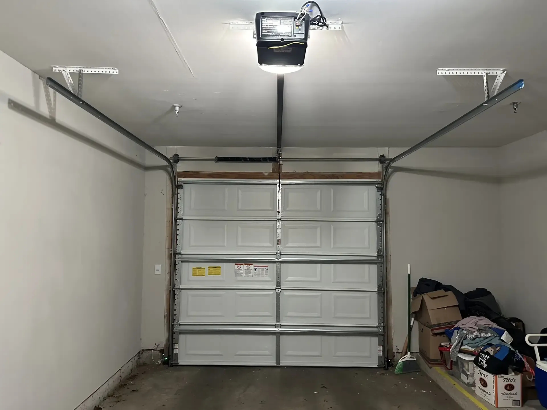 A garage with a garage door open and a garage door opener.