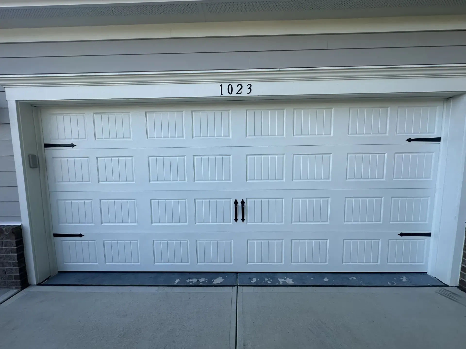 A white garage door with the number 1023 on it