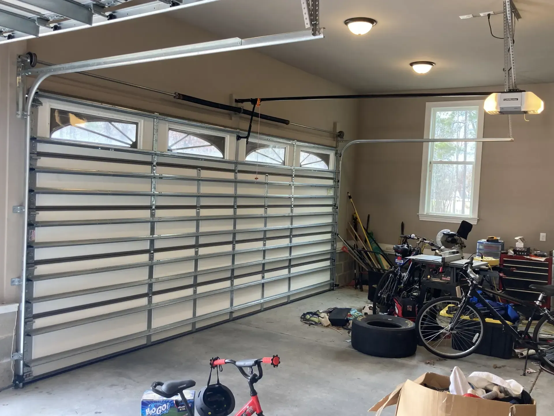 A garage with a large garage door and bicycles in it.