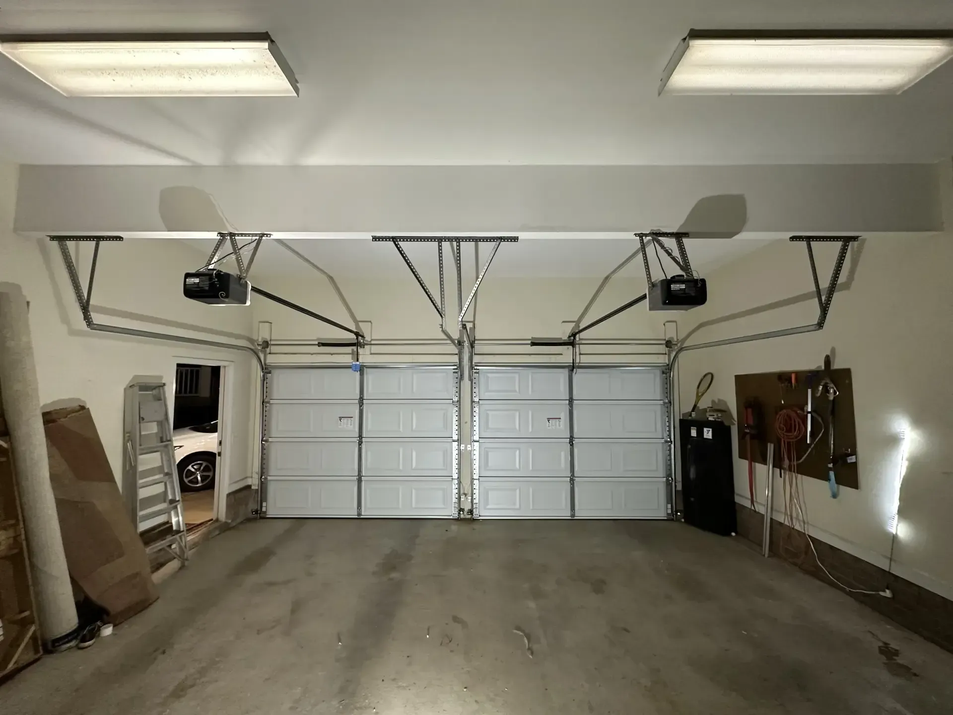 An empty garage with a white car parked in it