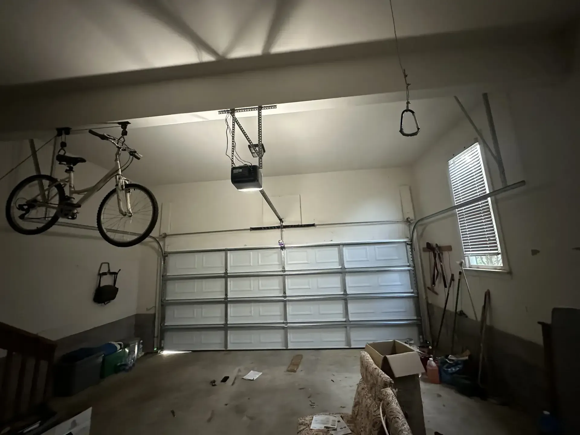 A bicycle is hanging from the ceiling of a garage