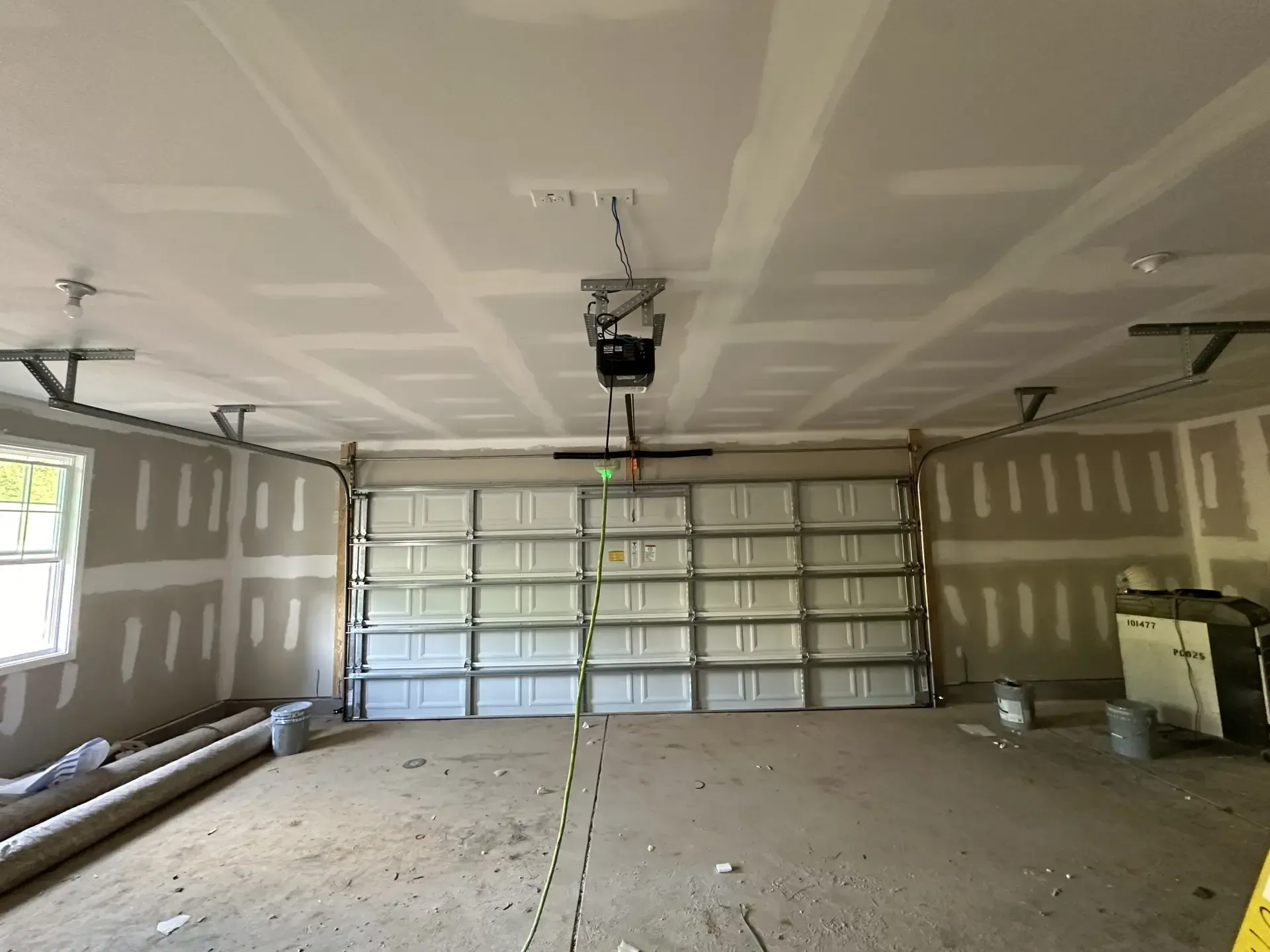 A garage with a garage door open and a ceiling fan.