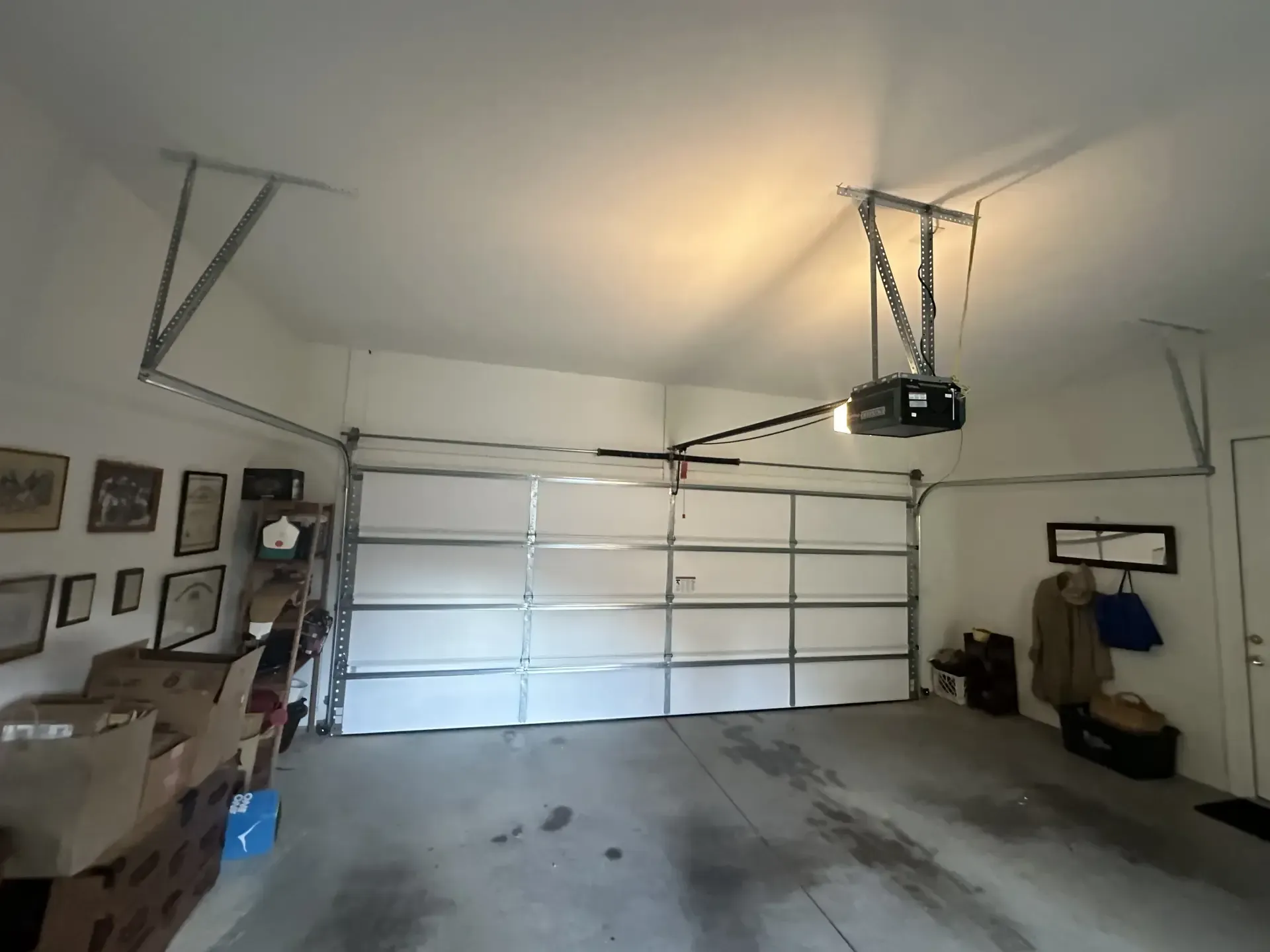 A garage with a garage door open and boxes on the floor
