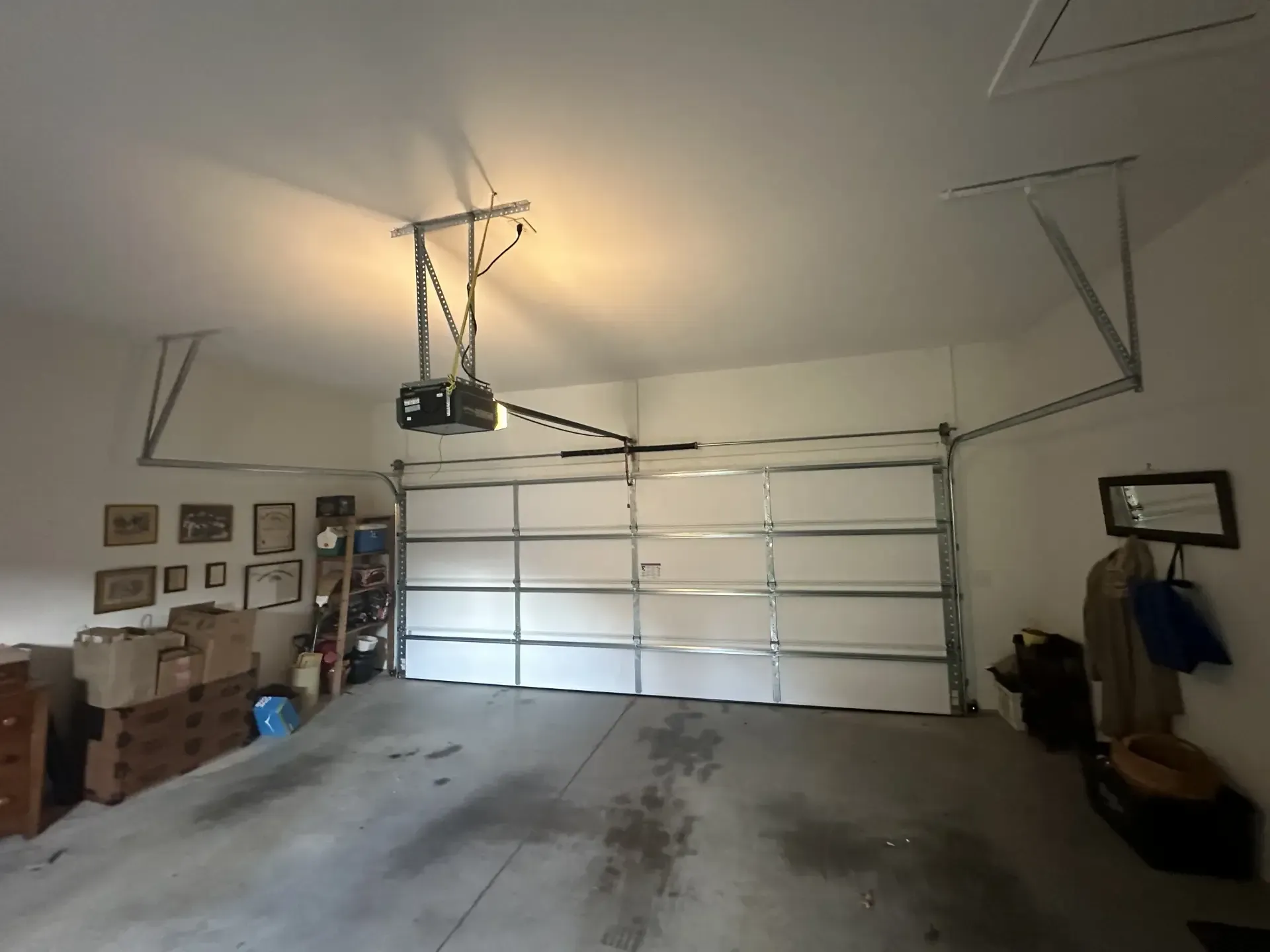A garage with a garage door open and a ceiling fan.