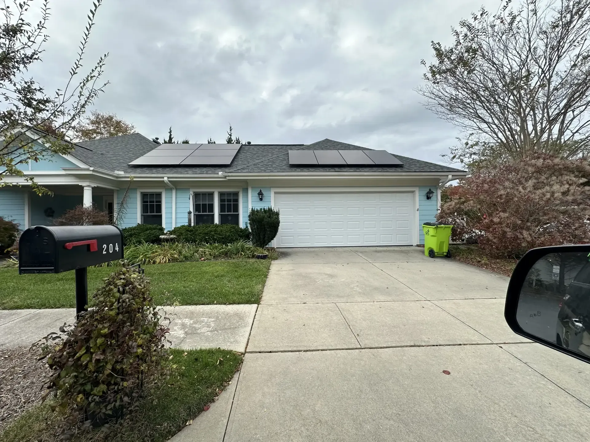 A house with solar panels on the roof and a mailbox