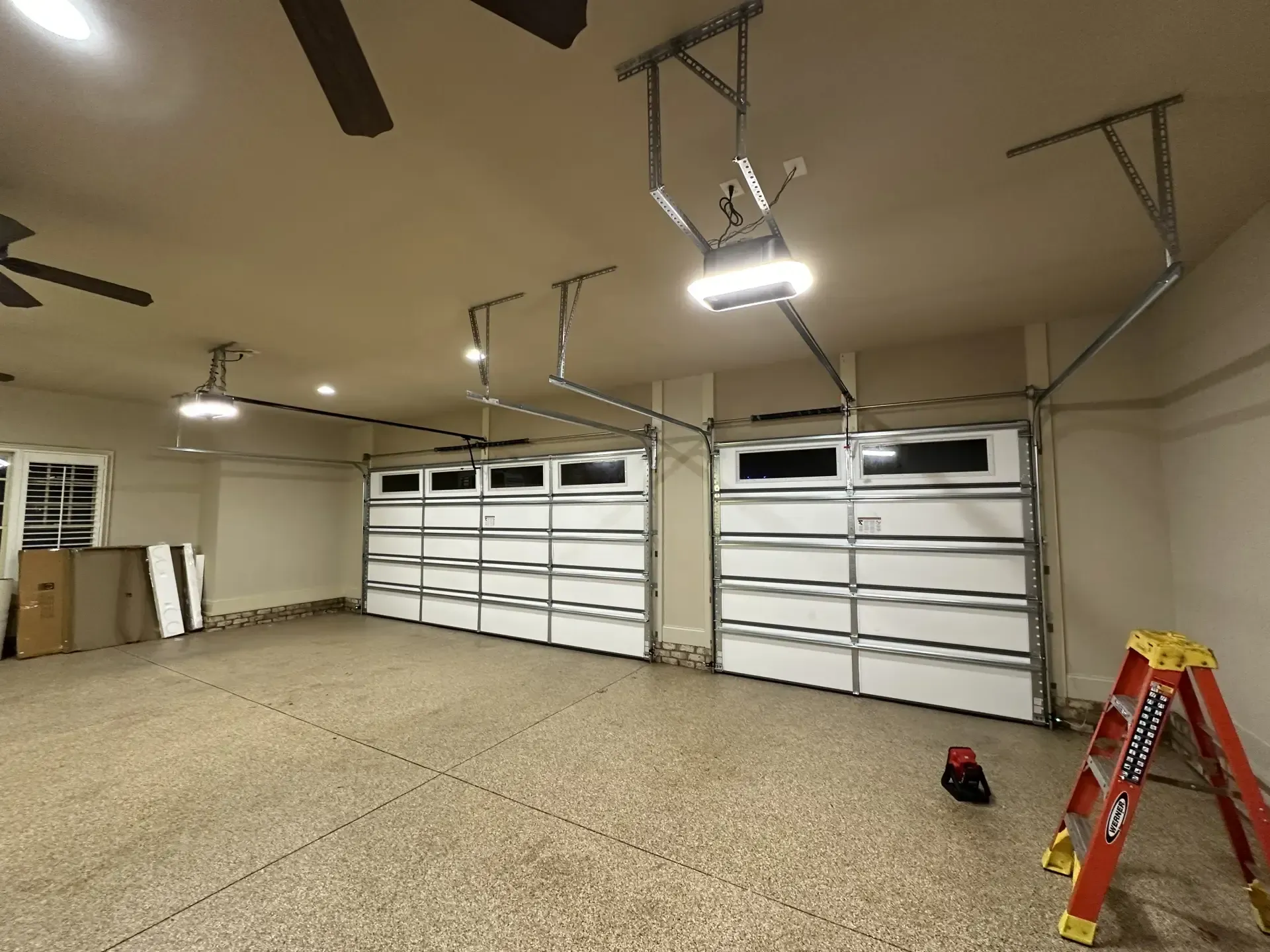 A garage with a lot of garage doors and a ladder.