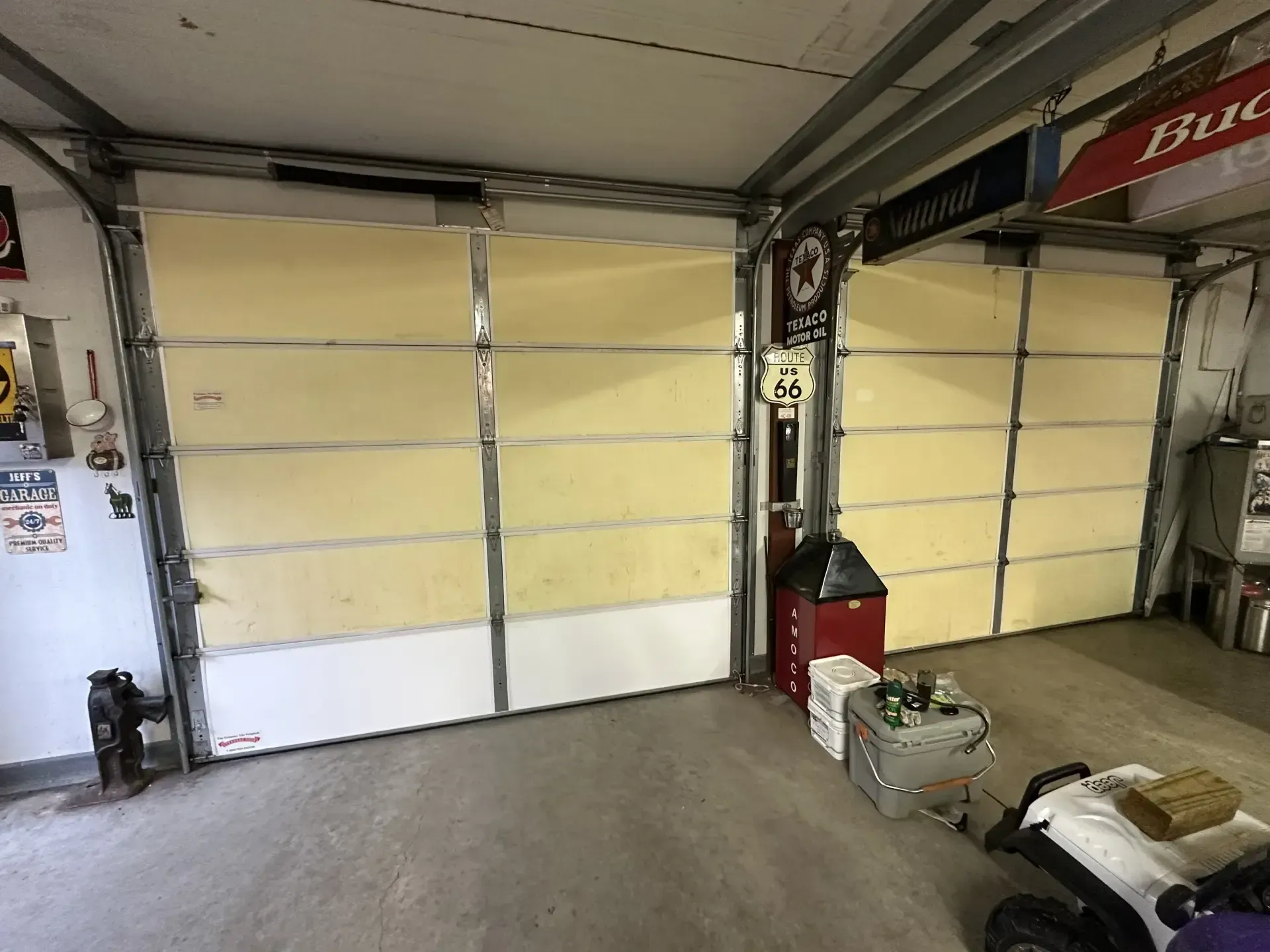 A garage with a golf cart parked in front of a garage door.