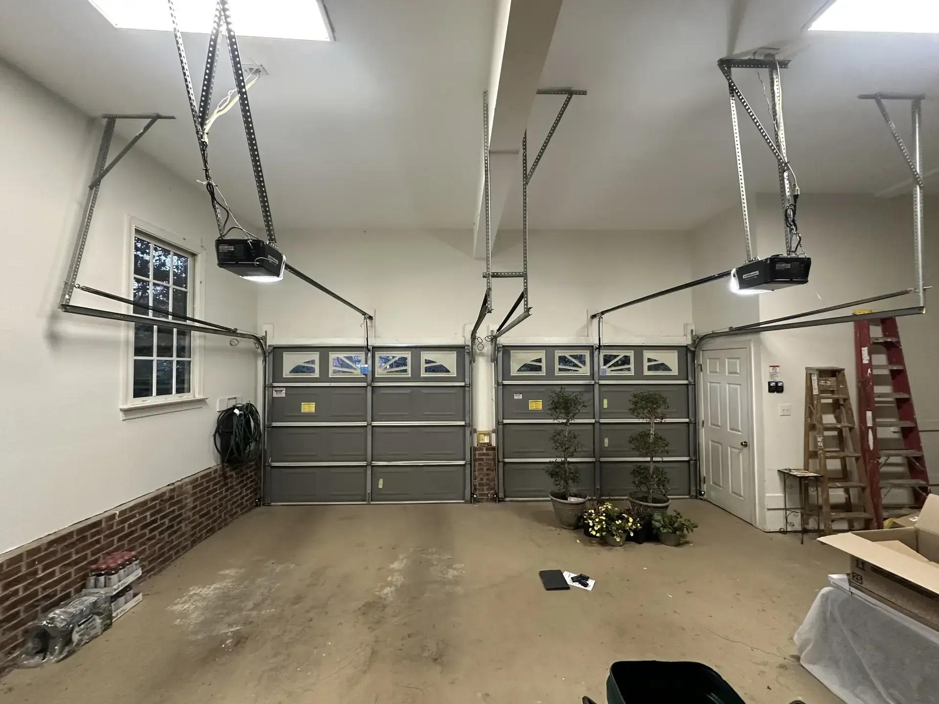A garage with two garage doors and a ladder.