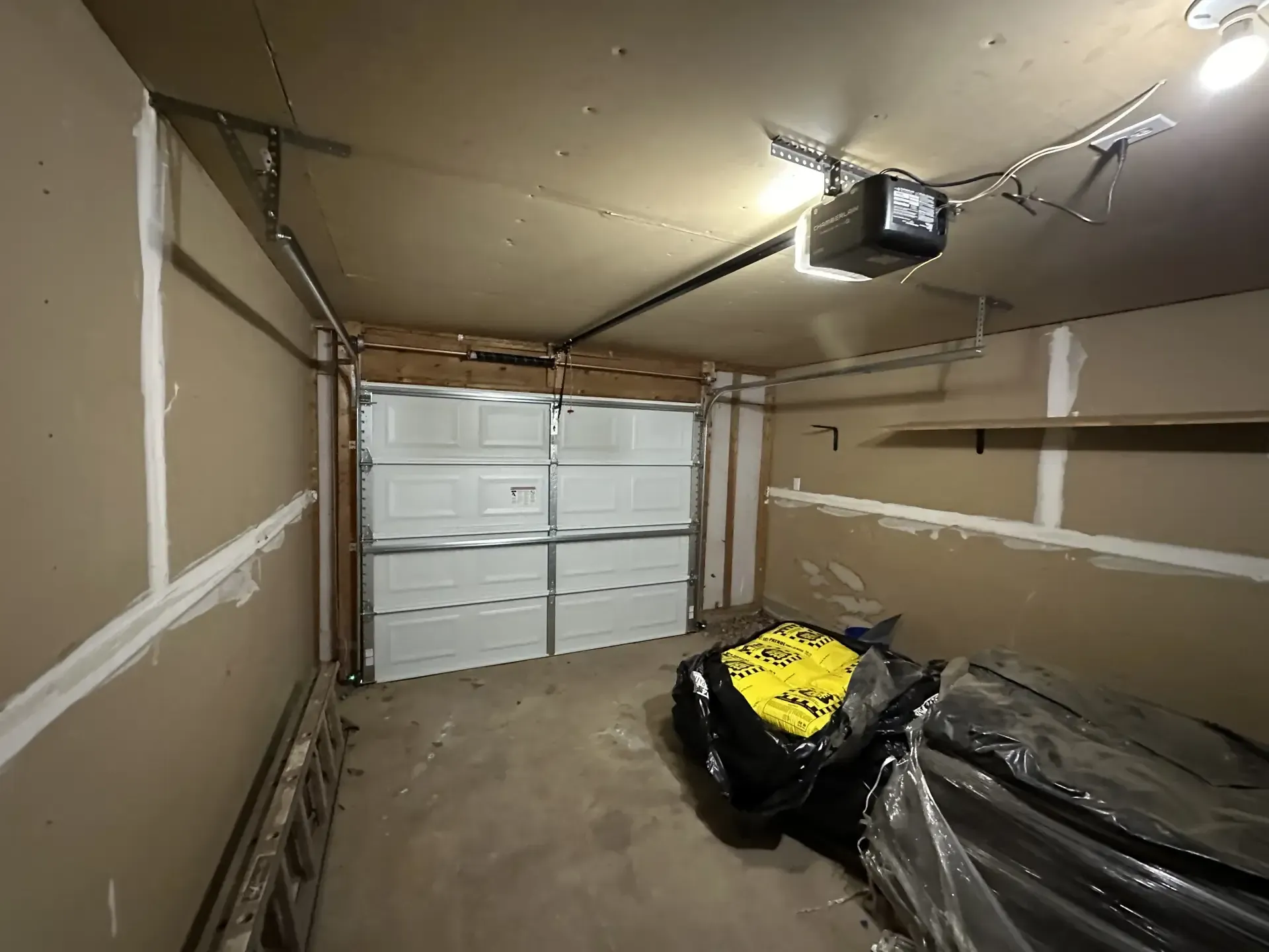A garage with a garage door open and a garage door opener.