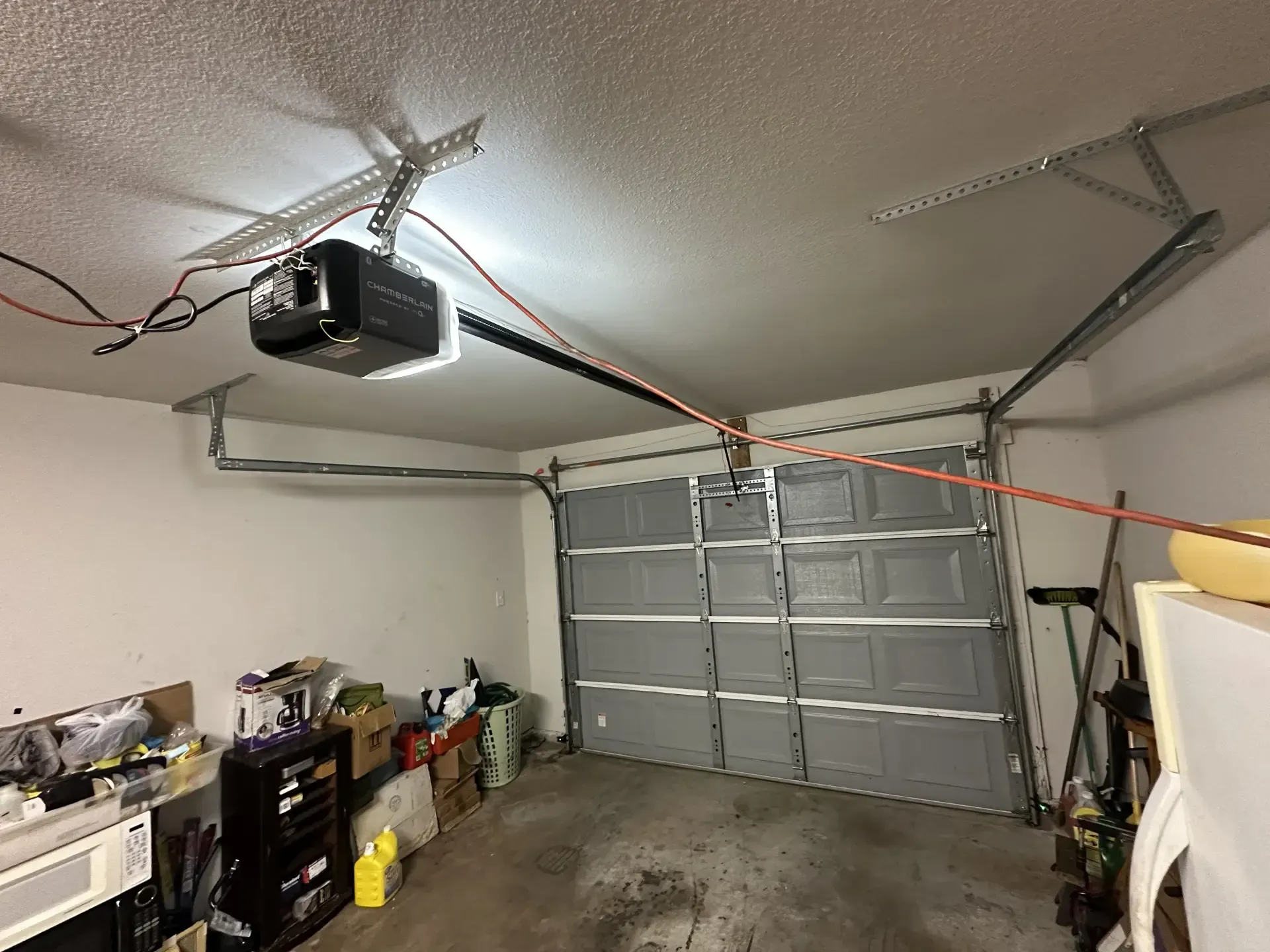 A garage with a garage door open and a garage door opener.