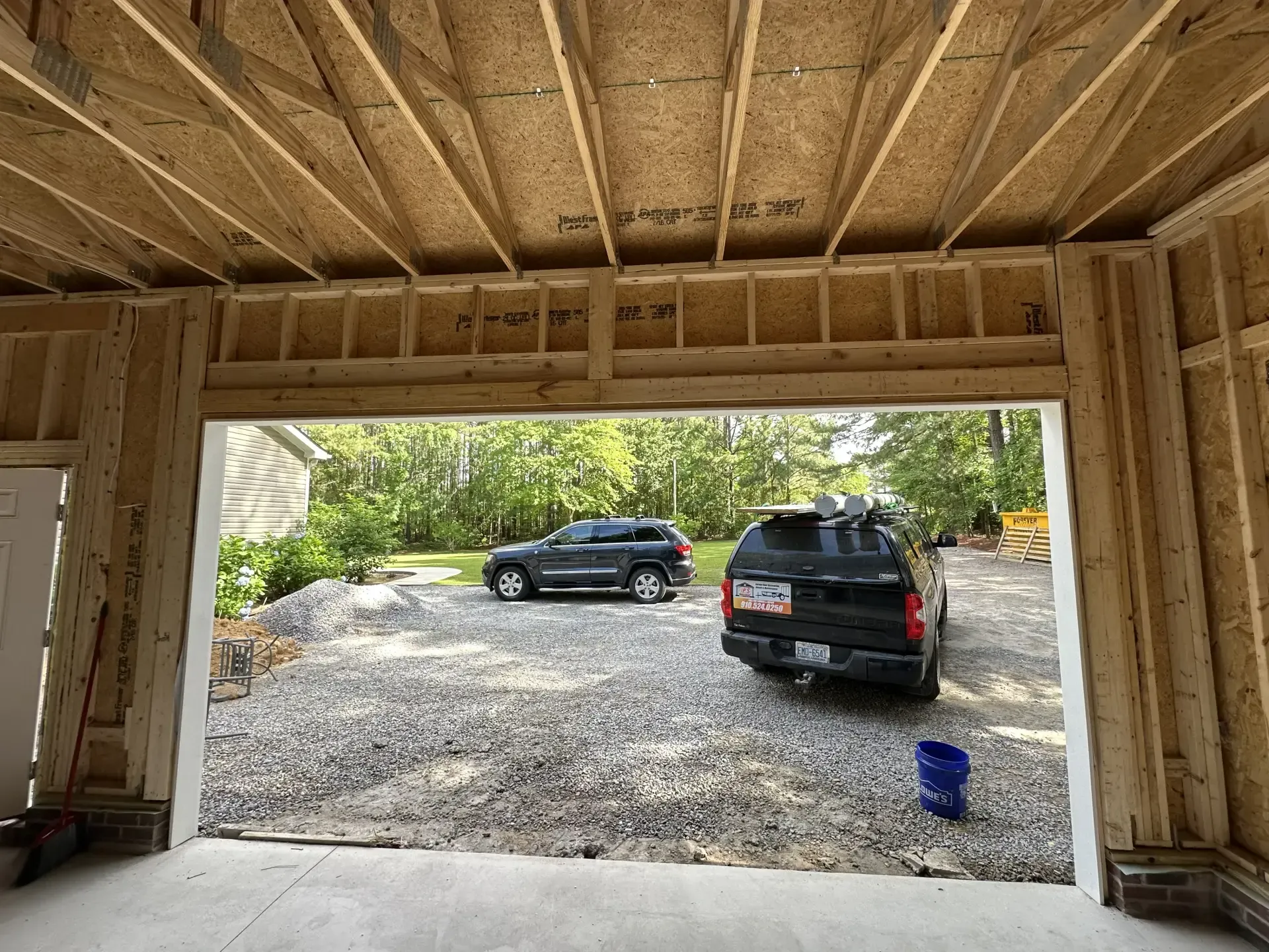 A car is parked in a garage under construction.