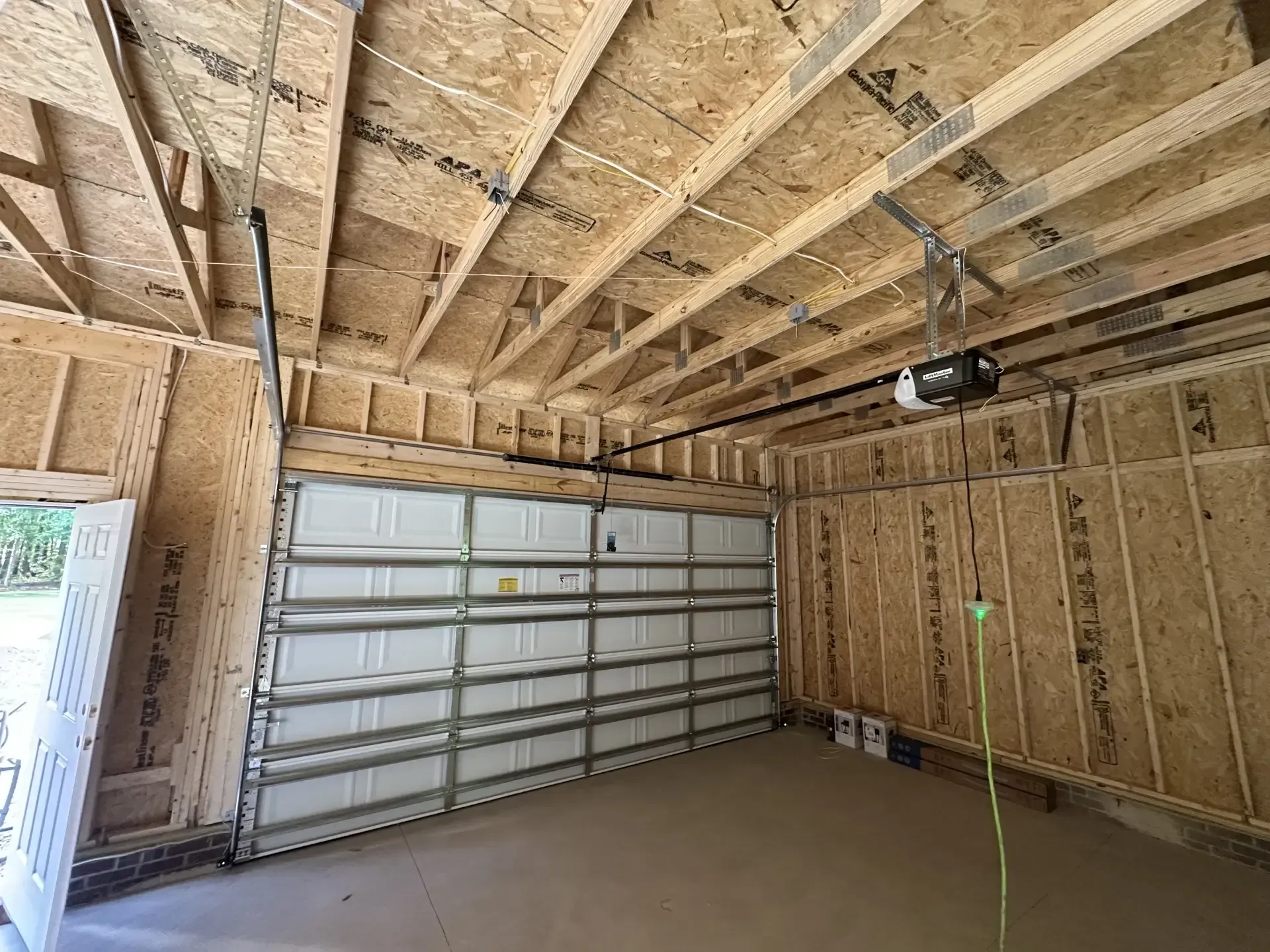 A garage under construction with a garage door open.