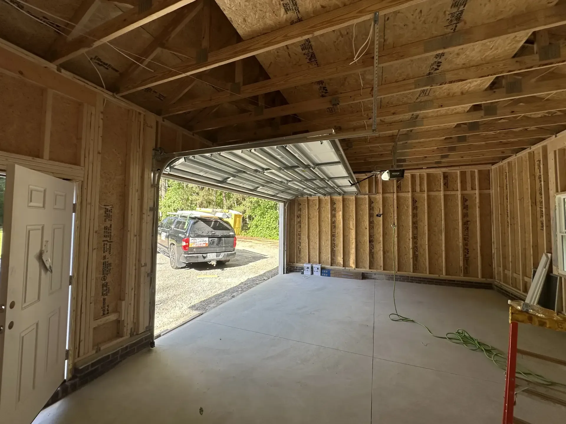 A car is parked in a garage under construction.