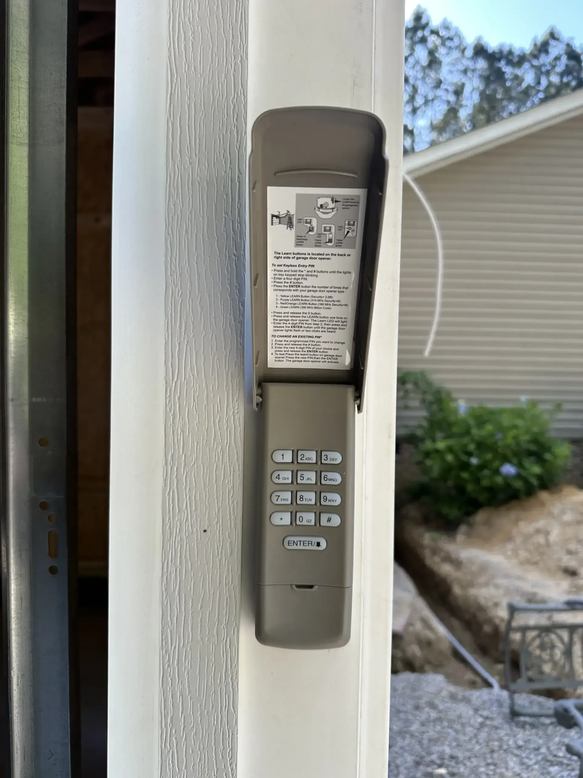 A remote control is attached to the side of a garage door.