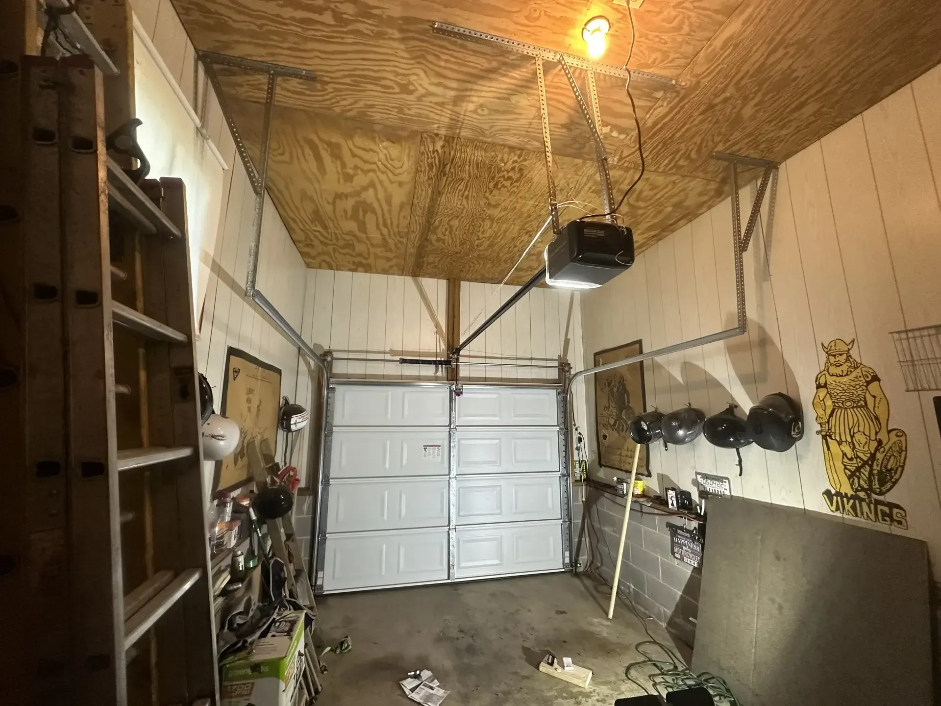A garage with a garage door open and a light on the ceiling.