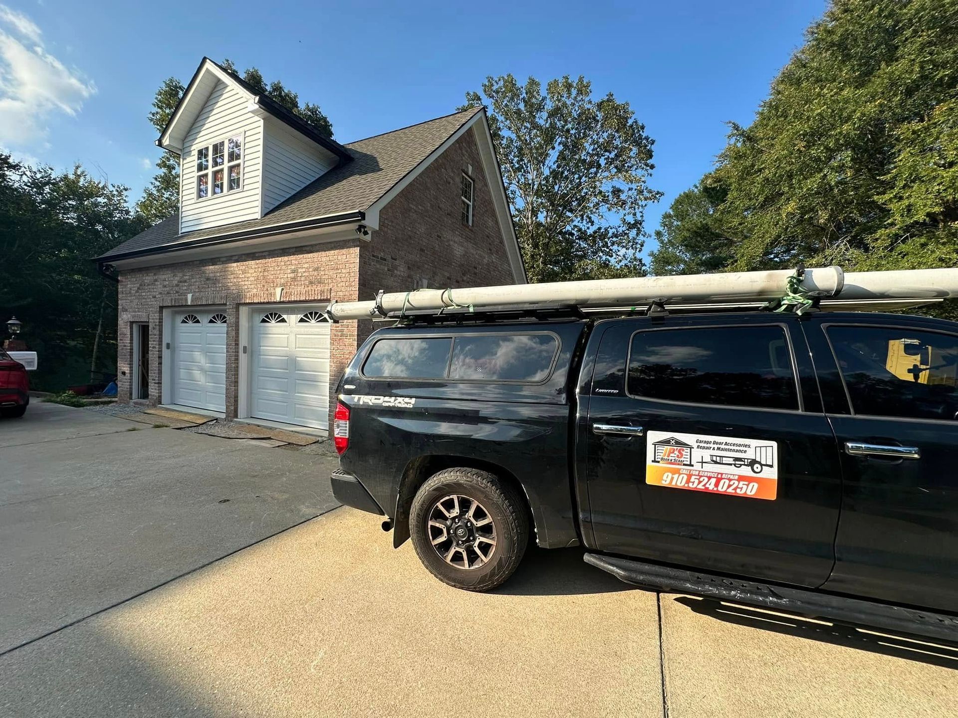 A black truck is parked in front of a house.
