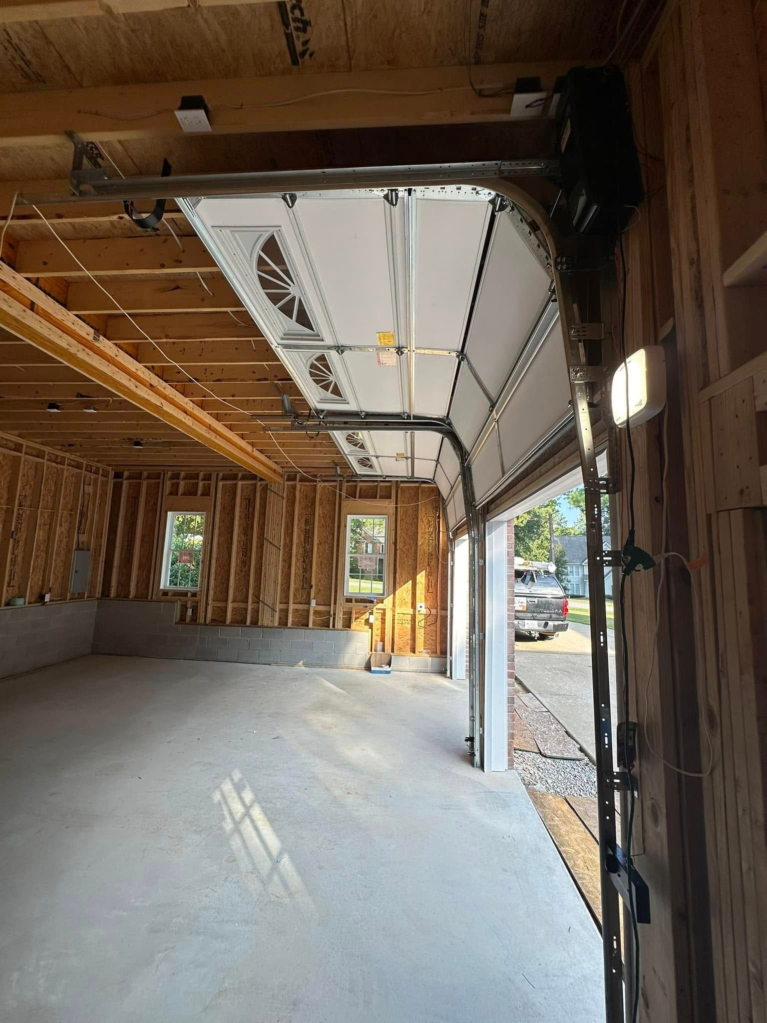 The inside of a garage under construction with the door open.