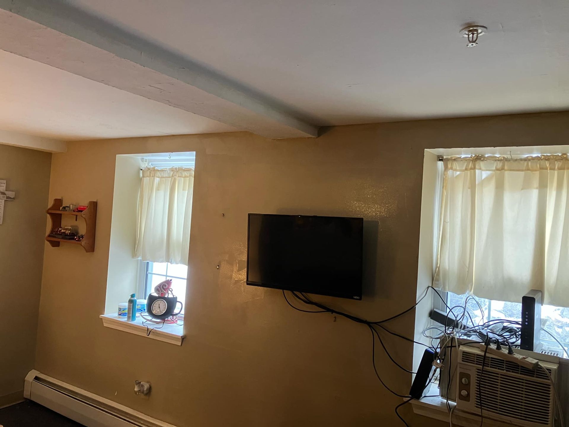 A living room with a flat screen tv mounted on the wall.