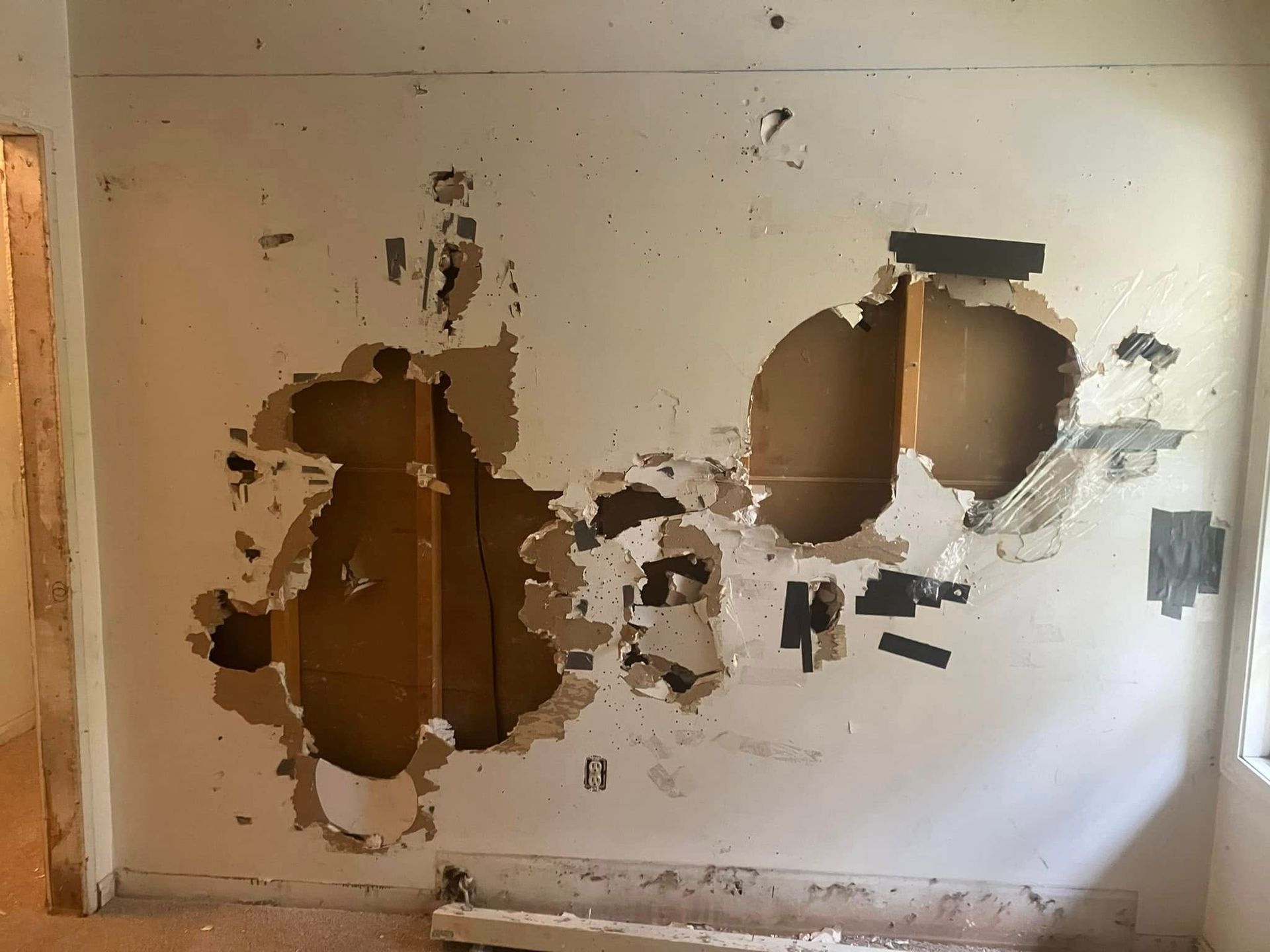 A wall with holes in it is being remodeled.