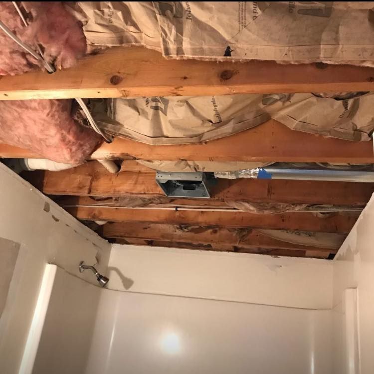 A bathroom with a ceiling that is missing insulation