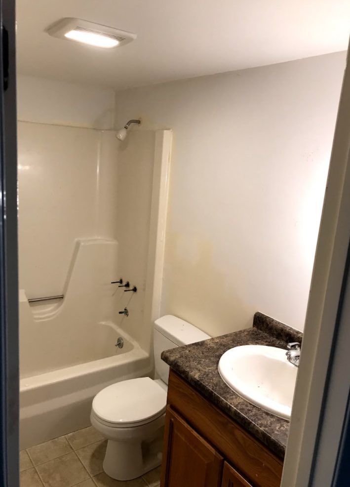 A bathroom with a toilet , sink , bathtub and shower.