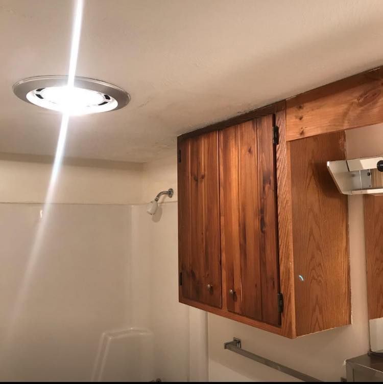 A bathroom with wooden cabinets and a light on the ceiling