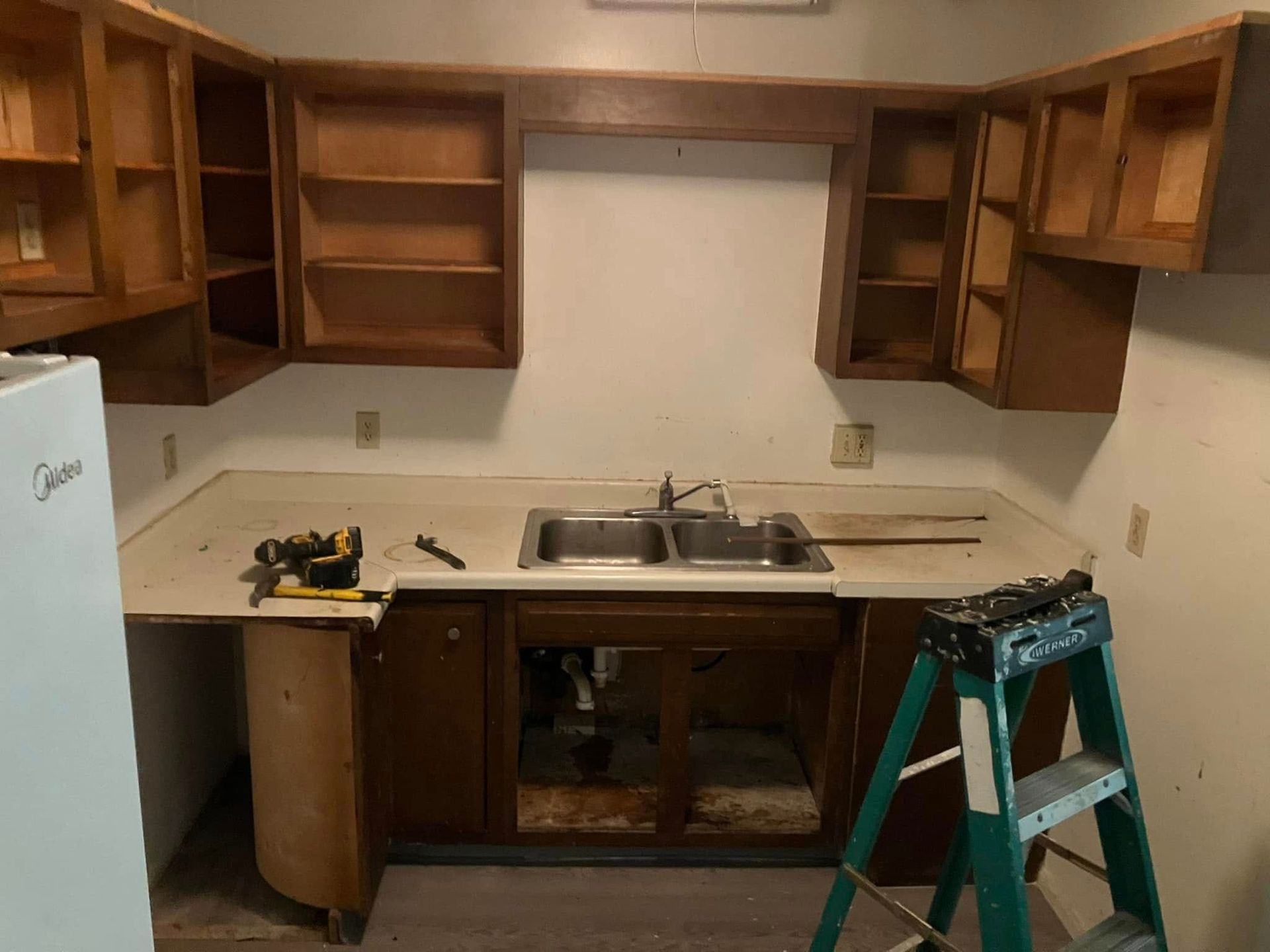 A kitchen with a sink and a ladder in it