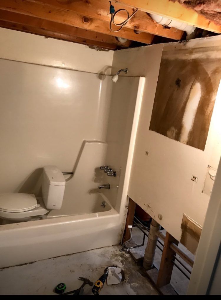 A bathroom with a toilet , bathtub and shower.