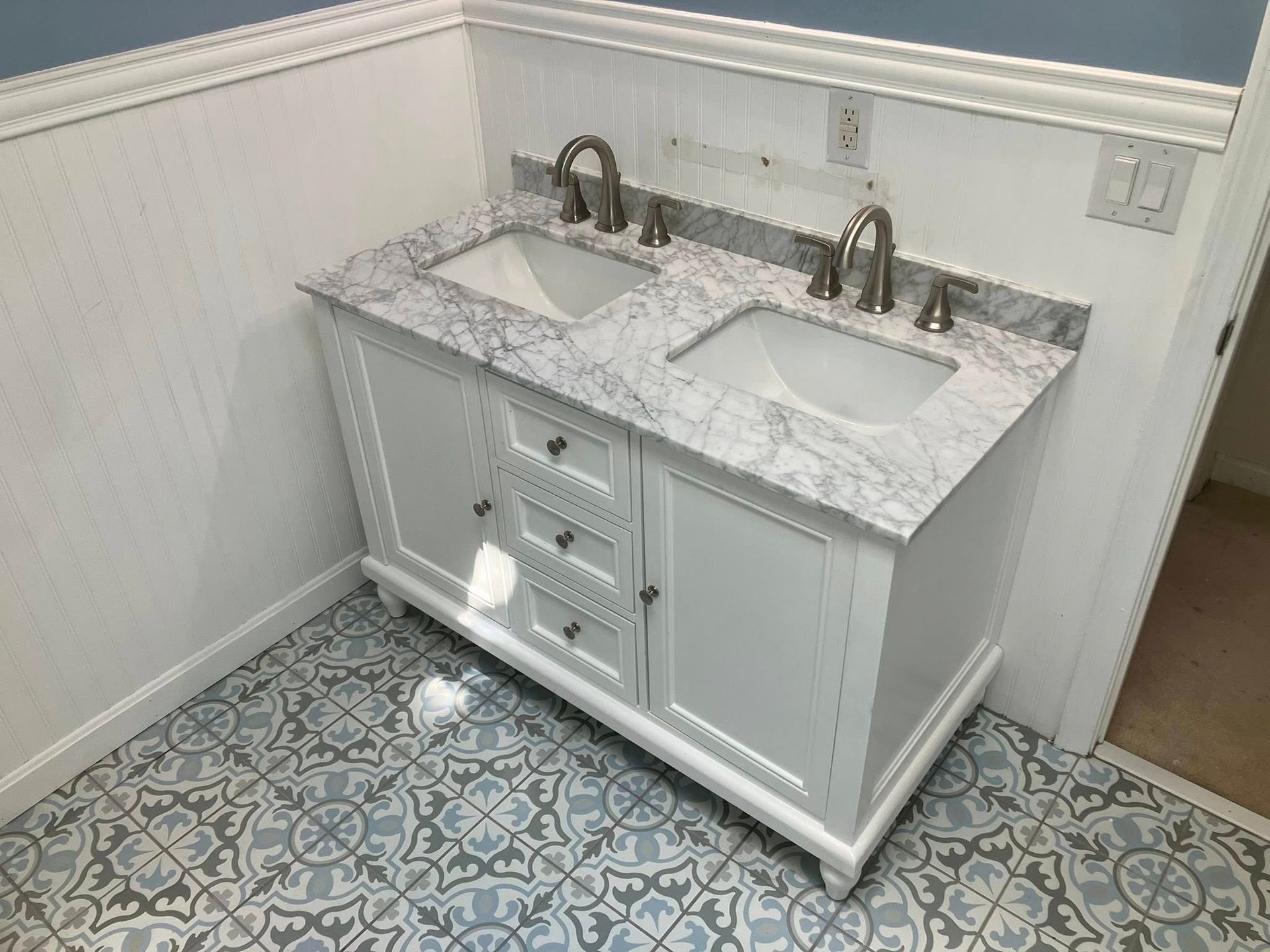 A bathroom with two sinks and a tiled floor.