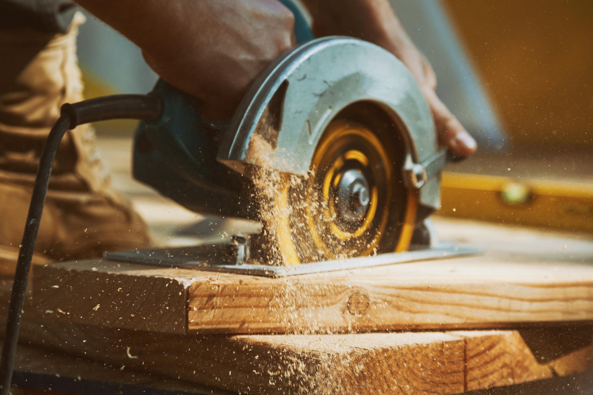 A person is using a circular saw to cut a piece of wood.
