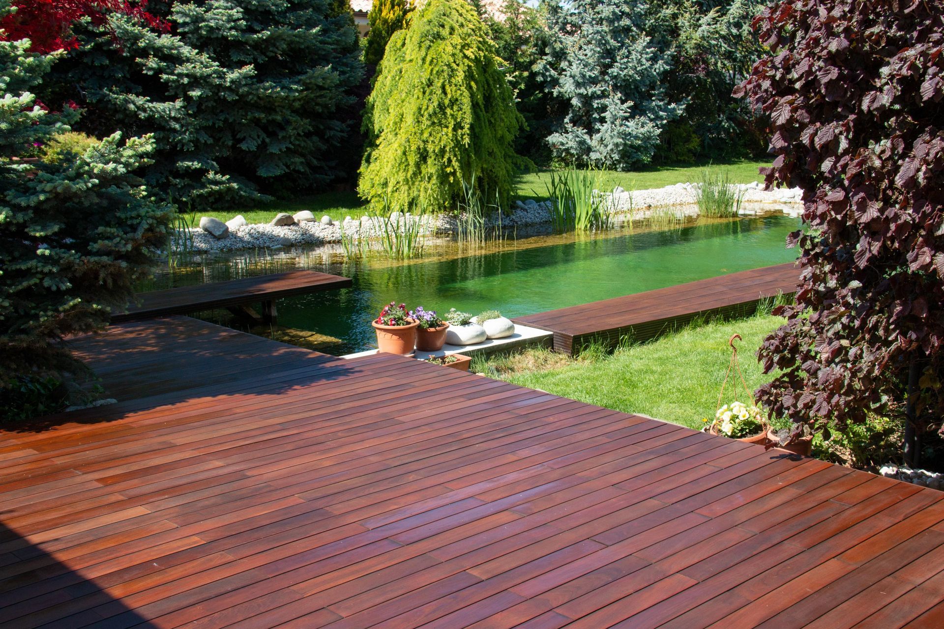 A wooden deck with a pond in the background