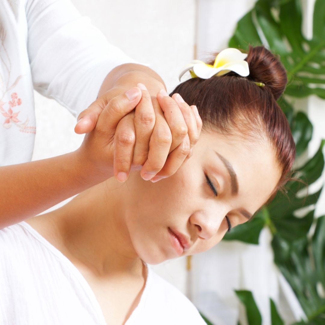 Eine Frau bekommt eine Massage mit einer Blume im Haar