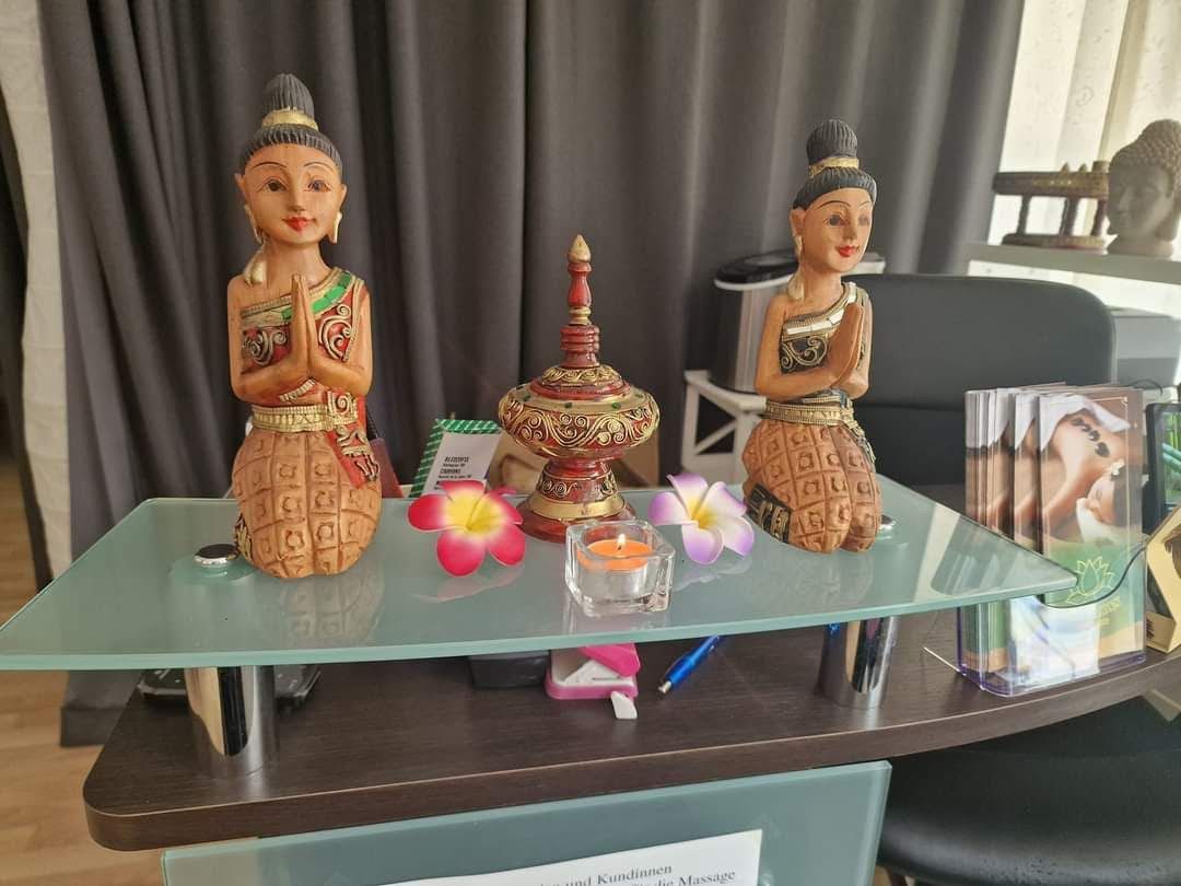 Drei Statuen stehen auf einem Glastisch in einem Raum.